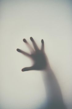 Dont get trapped in debt. Defocussed shot of a single hand reaching out against a plain background.