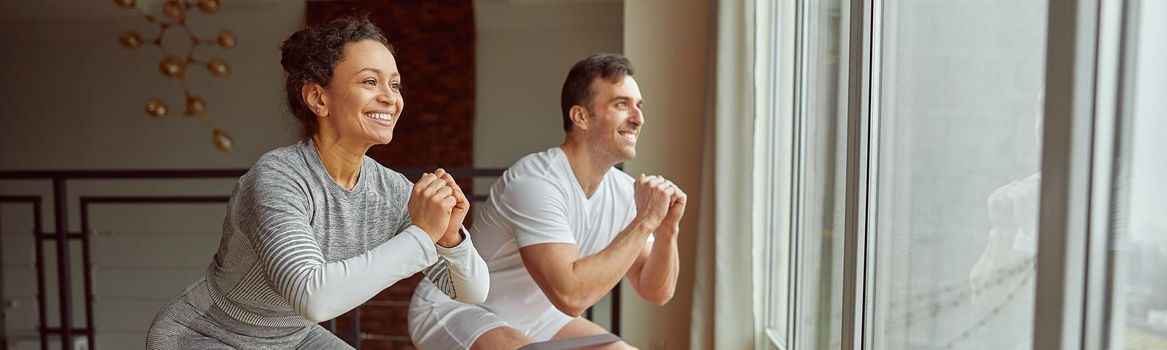 Joyful couple doing strength workout at home
