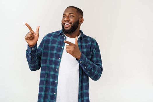 Young amazed African American pointing his finger at white background with copy space for your advertisement