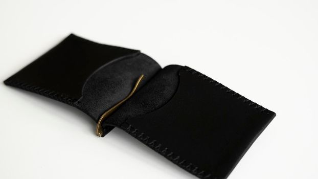 Open black money clip handmade from genuine leather on white surface.