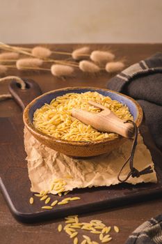 Dry risoni pasta in a ceramic bowl 