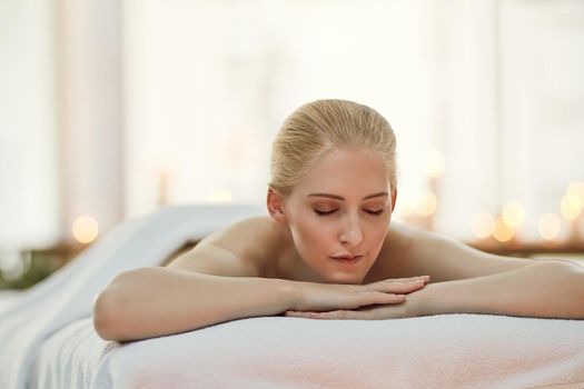 Relax, restore and renew yourself. a young woman relaxing on a massage table at a spa.