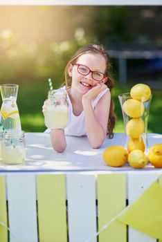 Its freshly squeezed. Portrait of a little girl selling lemonade from her stand outside.