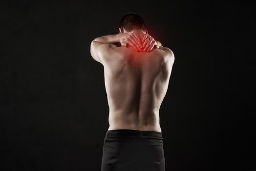 Urgent relief is needed for this pain. Studio shot of a sporty young man suffering with neck pain isolated on black.