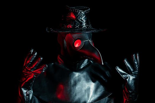Portrait of plague doctor with crow-like mask isolated on black background. Creepy mask, halloween, historical terrible costume concept. Epidemic