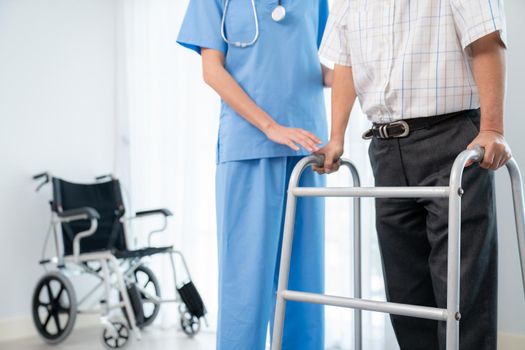Physiotherapist assists her contented senior patient on folding walker.