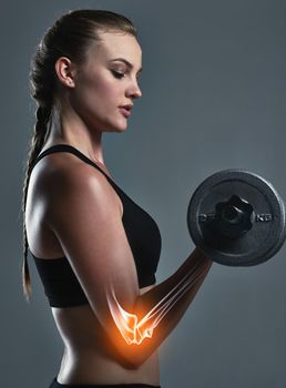 Im targeting a specific muscle. Studio shot of a sporty young woman building muscle in her arms.