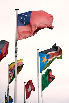 Representing many nations. the Samoan, Zimbabwean, Sudanese, Swiss and Swedish flags blowing in the wind.