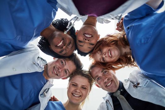 The best team here to give you the best care. Portrait of a group of medical practitioners with their heads together in a huddle.