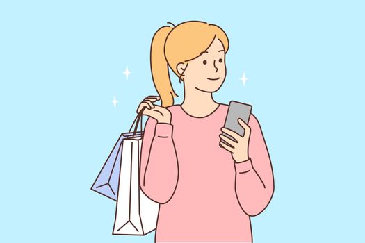 Happy woman with cellphone and shopping bags