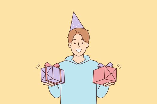 Smiling man holding birthday presents in hands