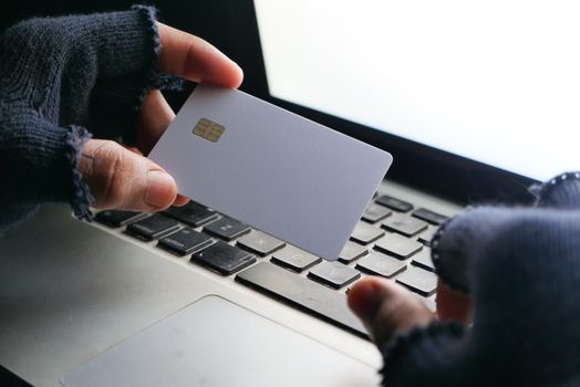 hacker hand stealing data from credit card