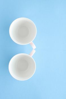 Empty cup and saucer on blue background, flatlay