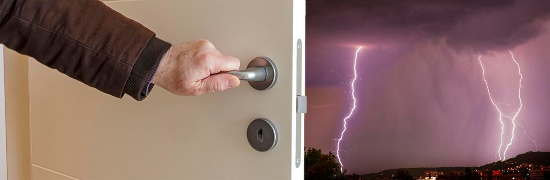 Close-up view of male hand opening door to thunderstorm with flash. Banner view