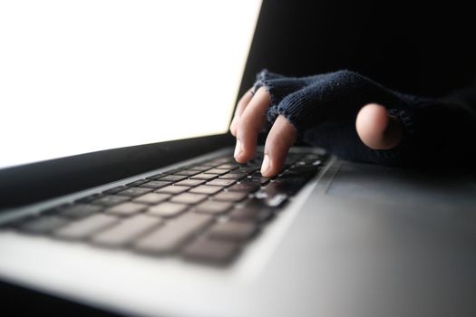 hacker hand stealing data from laptop top down