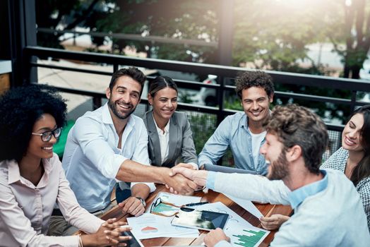 Congratulations on your latest success. businesspeople shaking hands during a meeting at a cafe.