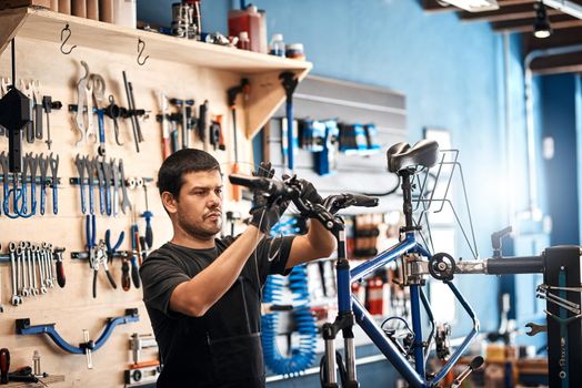 Focused on fixing your bike. a man working in a bicycle repair shop.