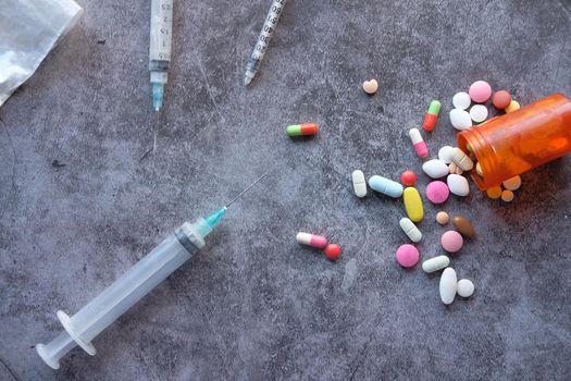 pills . drug and syringe on black background