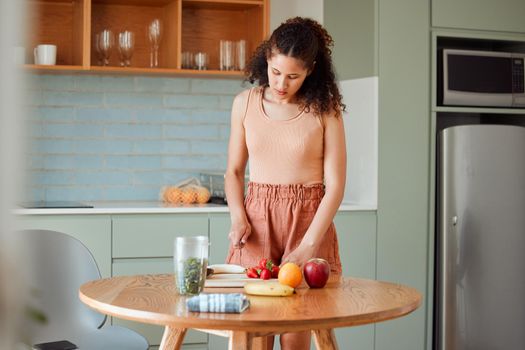 Healthy, wellness lifestyle and diet meal plan preparations or woman making breakfast fruit salad or smoothie on home kitchen table. Female preparing organic vegan food, cutting fresh ingredients.