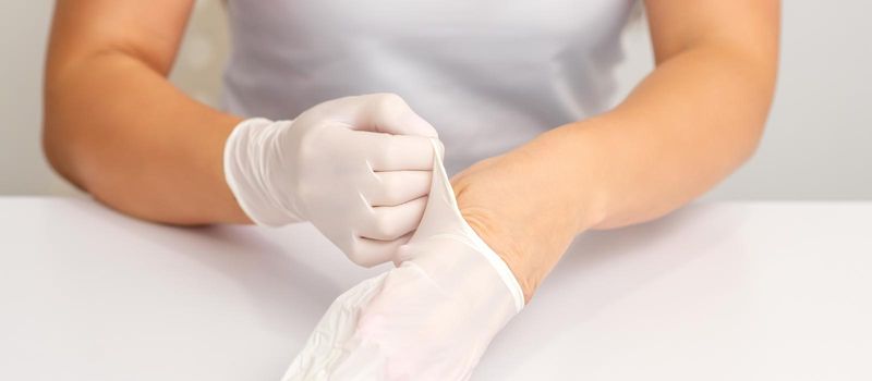 Doctor puts on white gloves