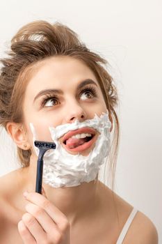 Woman shaving face with razor