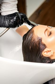 Hairdresser washing hair of client