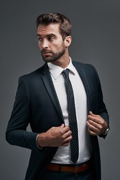 The main mission on his mind is success. Studio shot of a handsome young businessman posing against a grey background.