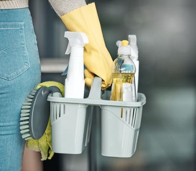Domestic worker, maid or cleaner hands holding or carrying cleaning products and equipment or supplies. For home hygiene, contact us for a handy helper agency or professional household service.