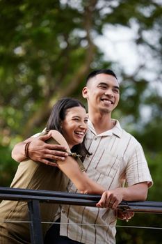Stylish, loving and carefree couple bonding and hugging showing affection in the park. Happy, cheerful and romantic african american couple embracing each other while standing and laughing outdoors