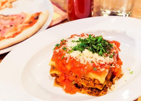 Lasagna bolognese plate, traditional recipe with tomato sauce, cheese and meat