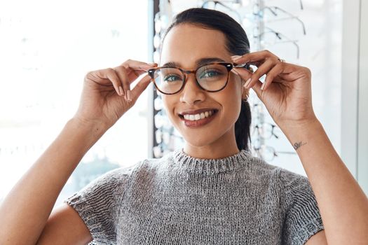 Glasses, vision and treatment by satisfied woman at optometrist, smiling and confident. Portrait of carefree female buying trendy spectacles to help with blurry vision, excited about her eyeglasses