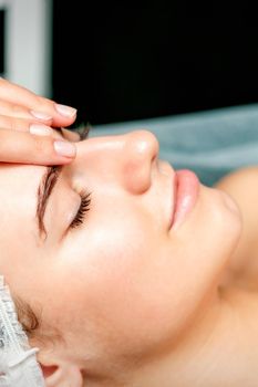 Female therapist making forehead massage
