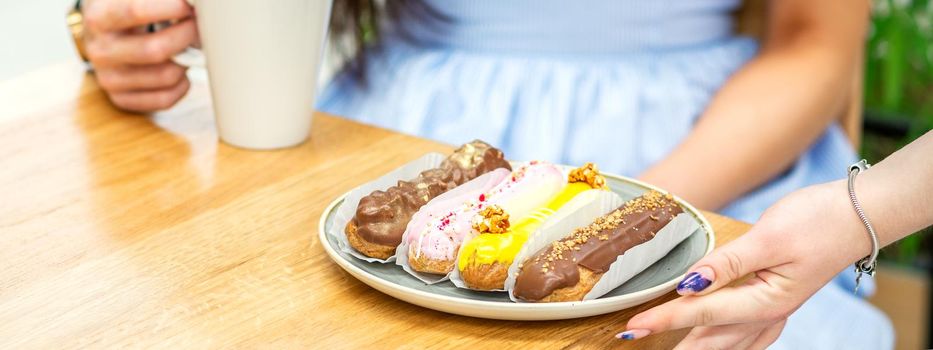 Waiter puts plate with eclairs