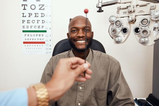 Black man having his eyes tested at an optometrist. Smiling African American male consulting with an opthamologist, having a vision and eye care checkup. Guy testing for glaucoma or myopia