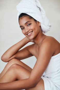 I make pampering part of my daily beauty routine. Portrait of an attractive and relaxed young woman wrapped in a towel at home.