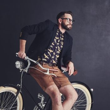 I wear my style, my way. a trendy young man posing in studio with his bicycle.