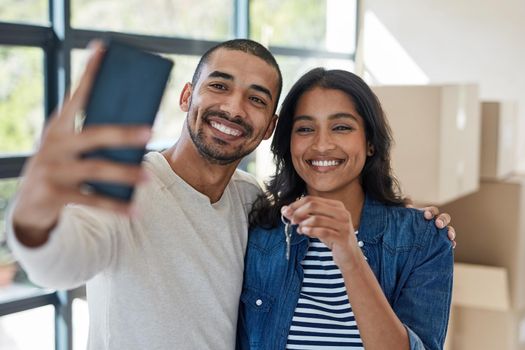 Its official. a happy young couple taking a selfie while moving into their new house together.