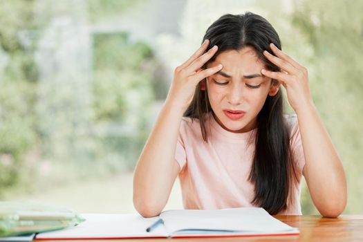 Stress, anxiety and worry with a little girl struggling with her studies, education and learning at home. Confused, frustrated and upset student having trouble with homework and difficult study