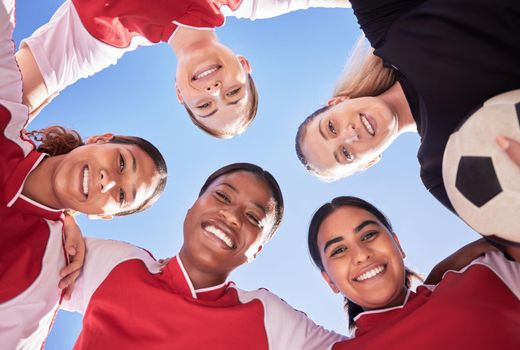 A soccer team of females only in a huddle during a match happy about winning the competition. Low angle portrait of a womens football squad standing in a circle in unity and support as game strategy