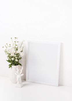 White frame mockup with chrysanthemum flowers in a vase on a white table