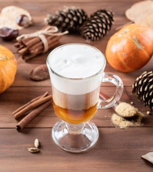 Pumpkin spice latte in a glass mug with cinnamon and ginger