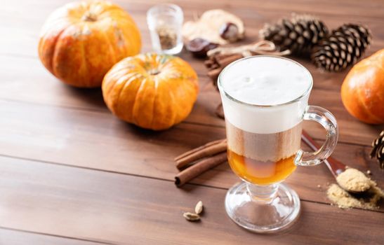 Pumpkin spice latte in a glass mug with cinnamon and ginger