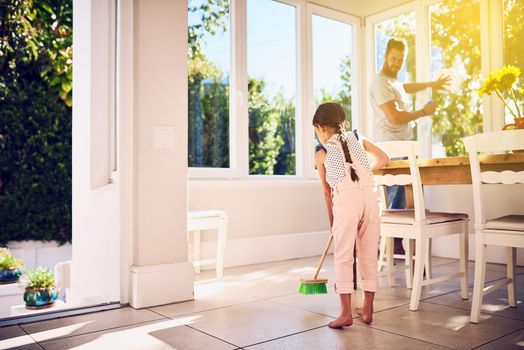 Chores are a great way to introduce responsibility to kids. a father and his little daughter doing chores together at home.