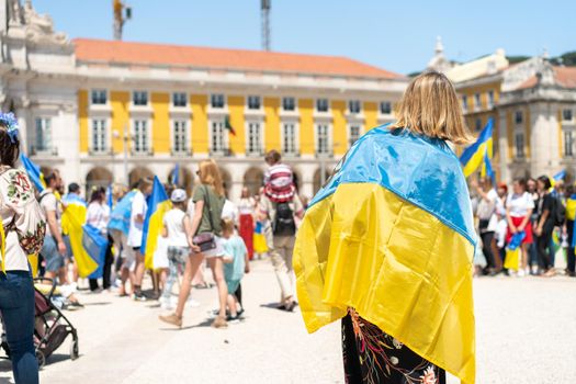 Portugal, Lisbon April 2022: The demonstration on Commerce Square in support of Ukraine and against the Russian aggression. Protesters against Russia's war Many people with Ukrainian flags.