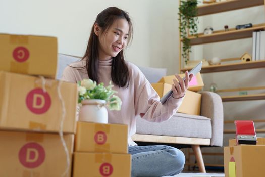 A businesswoman sells items online and checks the goods for packing