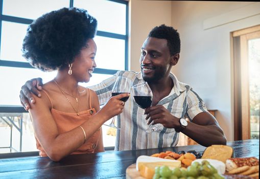 Celebration, love and black couple toasting with wine on a romantic date indoors, bonding and flirting. Lovers happy, in love and carefree, celebrating their anniversary and sharing intimate moment