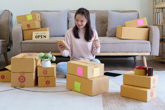 A businesswoman sells items online and checks the goods for packing