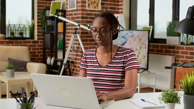 African american woman browsing internet on laptop at home