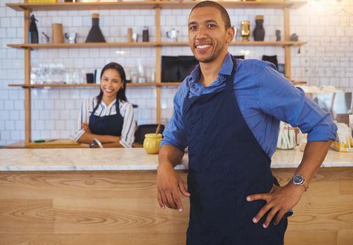 Small business owner or startup entrepreneur standing at a bar counter in a coffee shop or cafe as a team leader. Motivation, vision and teamwork with young people working in retail restaurant