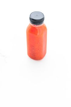 Detox red fruit smoothie juice in a bottle, diet catering delivery. Isolated on white background